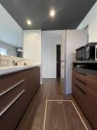 キッチン　家事をしながらコミュニケーションが取れる対面式キッチンは落ち着いた色でまとめられています。

